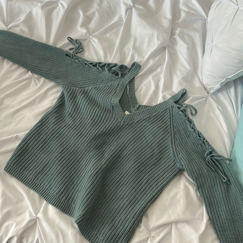 Sweater with open shoulders that tie down the arms. V Neck